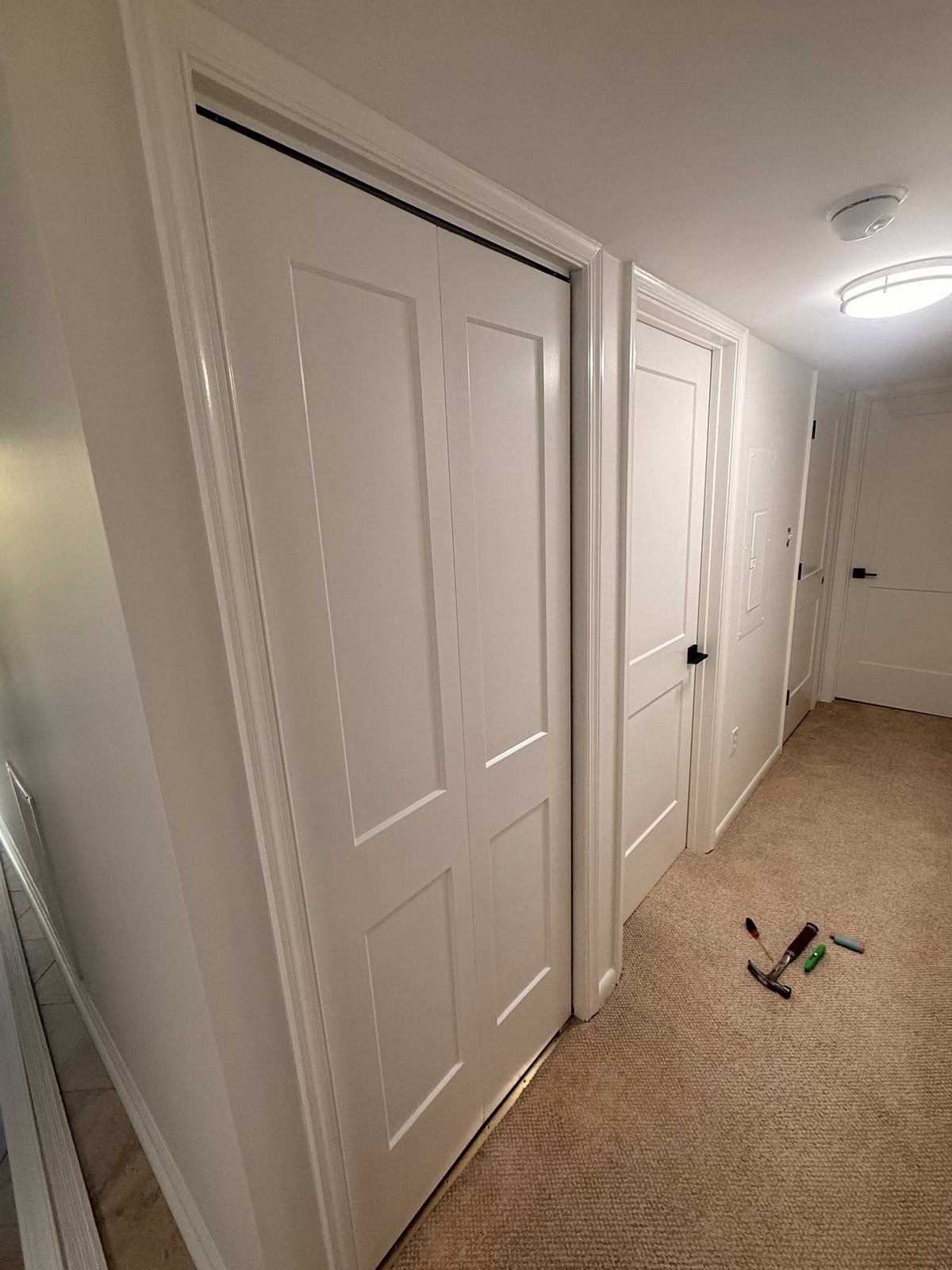 Eight new interior doors installed down a hallway, hinges aligned, hardware uniform