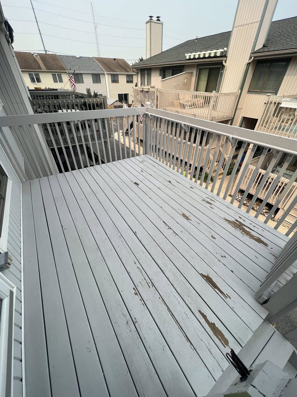 Before: weathered deck boards stained from a season of salt and traffic